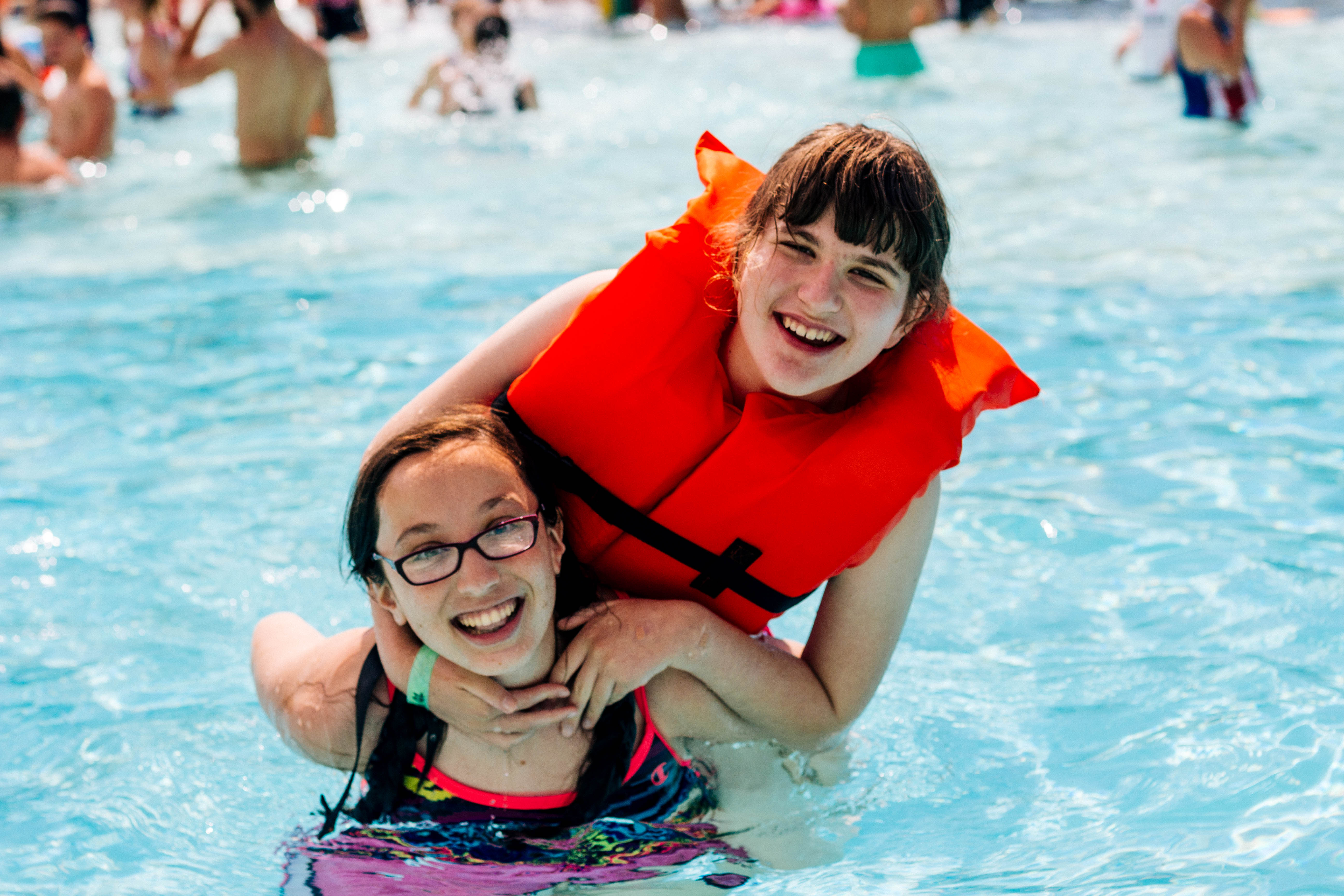 Two girls swim in an accessible swimming pool.