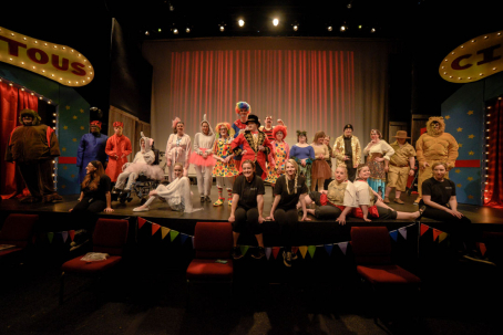 A group photo of student and professional actors and actresses on stage