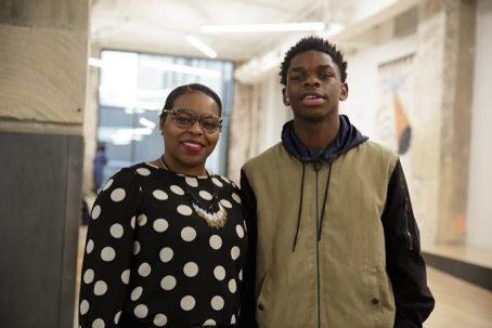 Tequilla and her son stand in front of a light background