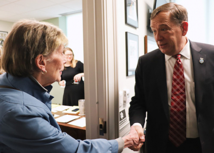 A woman greets her legislator.