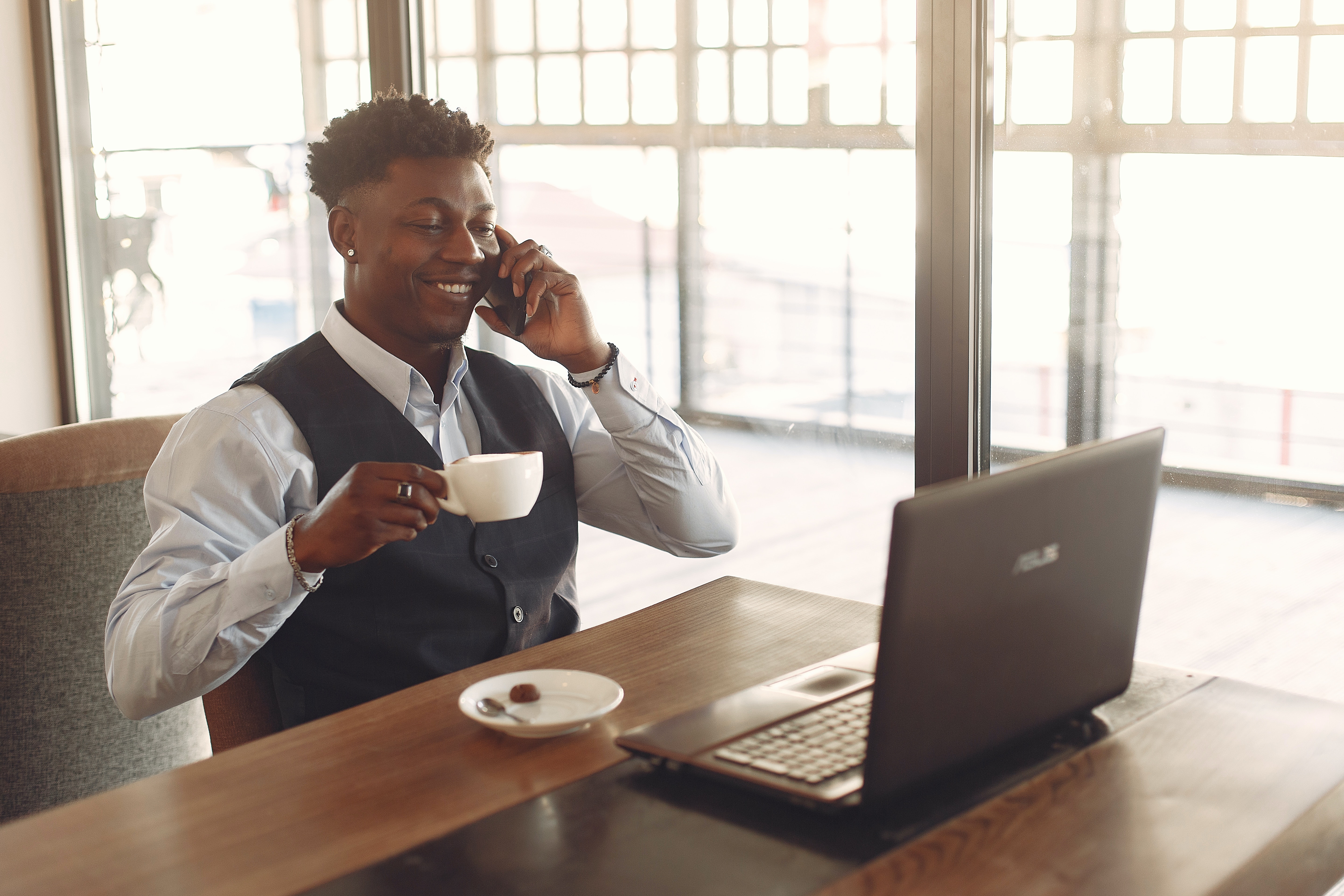 Male professional sitting at a desk drinking coffee