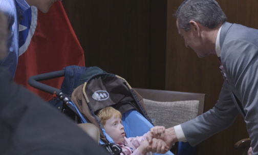 Speaker Geln Casada Shakes Young Boy's Hand As Mother Looks On