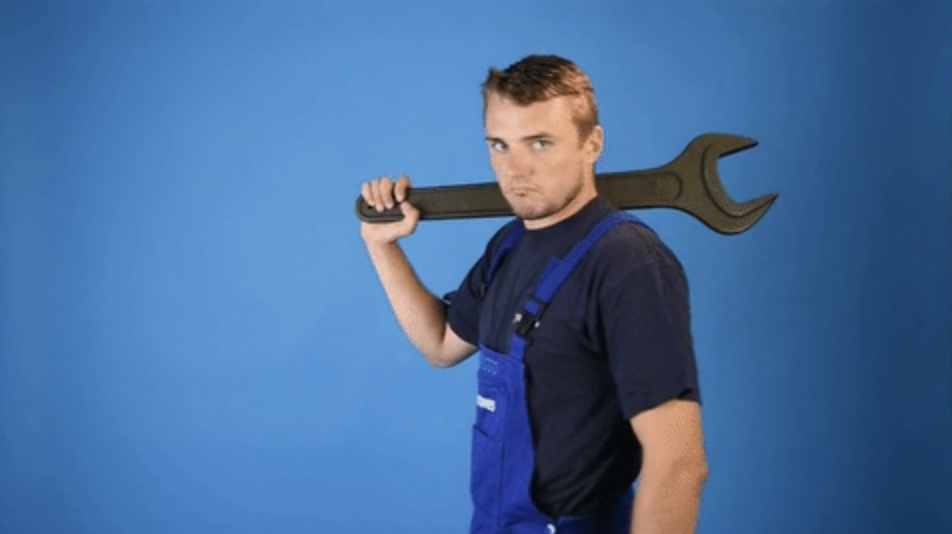 Man holding giant wrench over shoulder and nodding at camera
